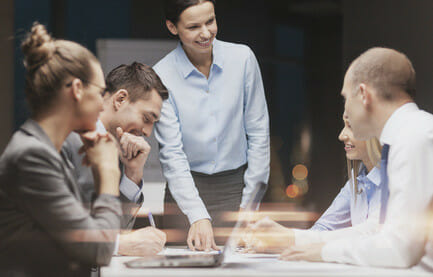 smiling female boss talking to business team